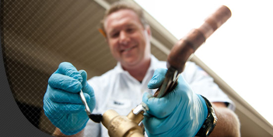 A Benjamin Franklin Plumbing plumber fixing a pipe in Lynchburg