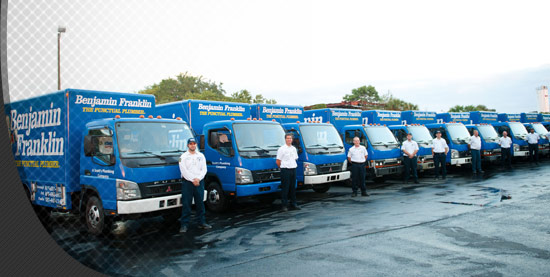 Benjamin Frankling Plumbing technicians standing near trucks.